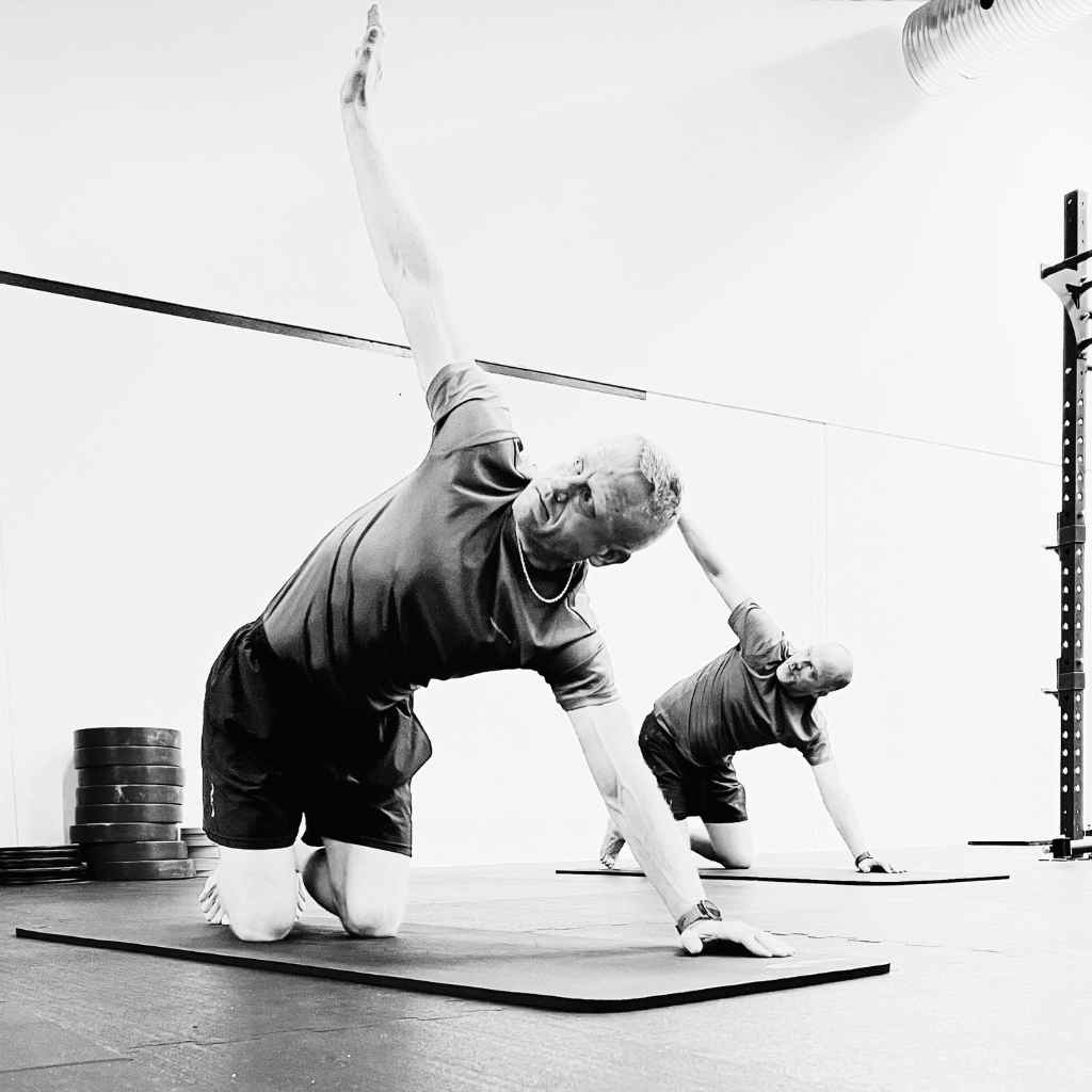 2 mænd dyrker yoga til holdtræning i Keep Fit