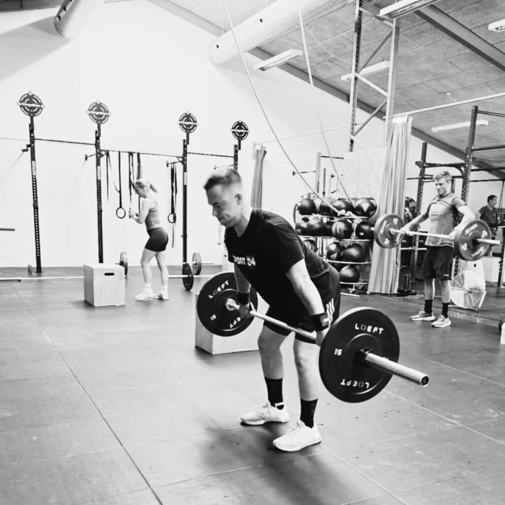 Mand laver træningsøvelsen snatch med en barebell til træning i Keep Fit