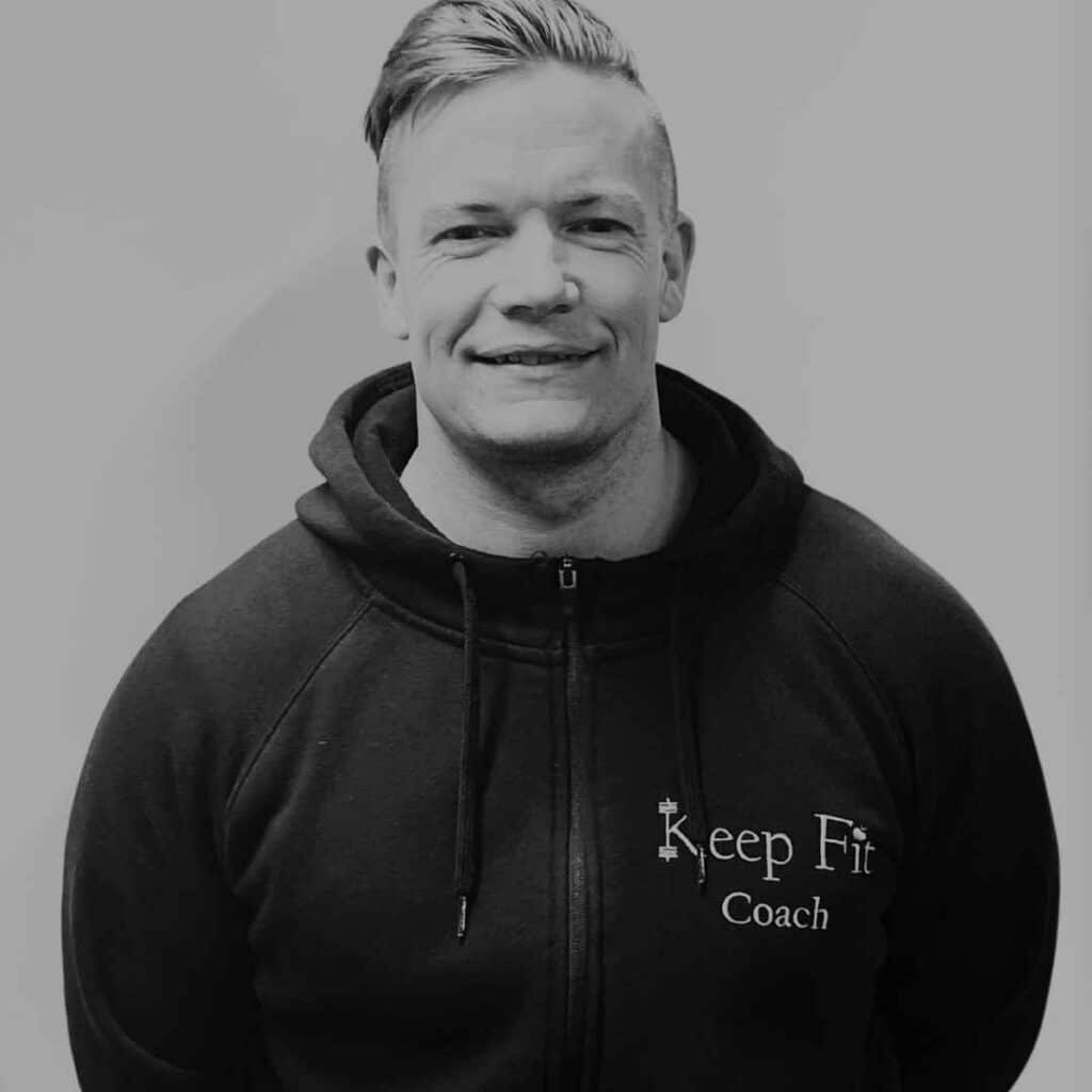 Coach Rasmus står i sin Keep Fit hoodie og smiler ind i kameraet
